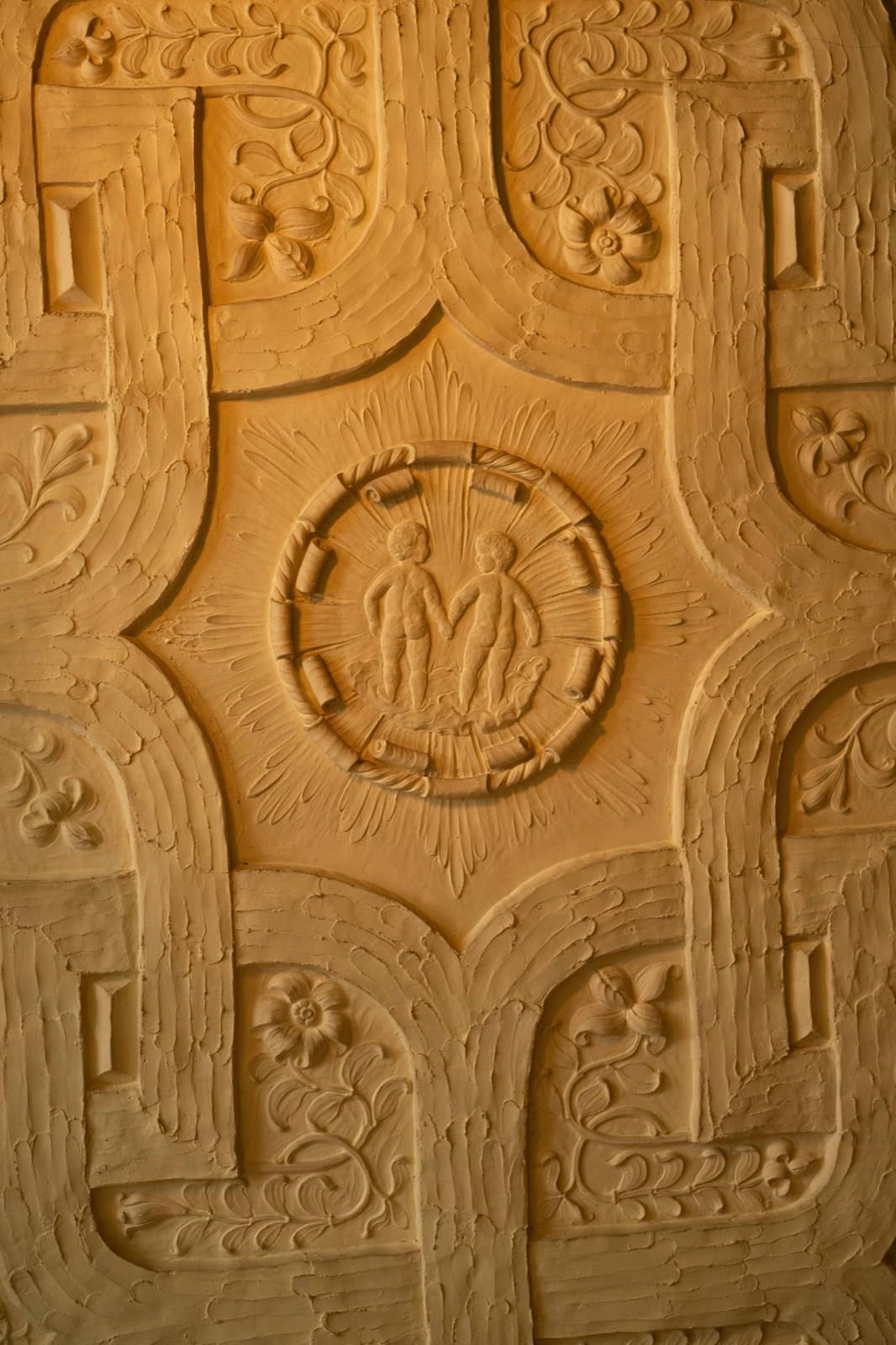 Arts and Crafts carved oak panel at Tjolöholm with two small figures in a medallion
